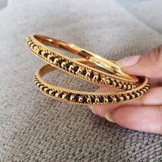 "* Handcrafted Gold Plated 2 Bangle Set. Sold as a set. * Bangles with prettY Black and gold color beads. * High Quality 22 K Gold Plated- 2 Bangle set * Bangles Sizes : 2.4 inches= ( 2.25\" diameter of the inner circle) ; 2.6 inches = ( 2.45\" diameter of the inner circle); 2.8inches = (2.54\" diameter of the inner circle) Gorgeous gold-plated bangle/ bracelet best exemplifies the careful craftsmanship done on it -- a specialty at Nemali Jewelry. It has a special tone of elegance attached to it Gold Beaded Bangle As Gift, Gold Beaded Bangle For Gift, Gold Bracelet With Round Beads For Festive Occasion, Festive Gold Bracelets With Round Beads, Festive Gold Bracelet With Round Beads, Traditional Gold Beaded Bracelets For Jewelry Making, Handmade Gold Bangle With Round Beads, Gold Bangle With Round Beads For Wedding, Traditional Gold Beaded Bangle