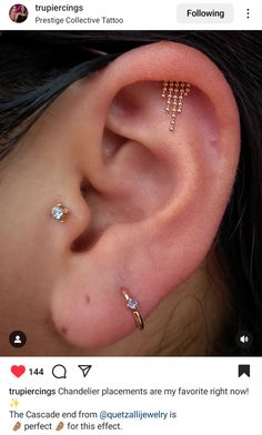 an ear with three different piercings attached to the middle of it, and two smaller ones