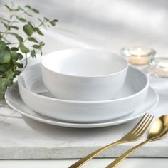 white plates and silverware on a marble table