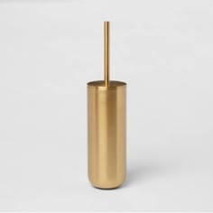 a gold toilet brush holder on a white background