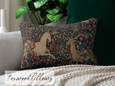 a decorative pillow with an image of two deers on it in front of a potted plant