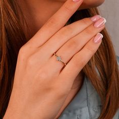 a close up of a woman's hand with a diamond ring on her finger