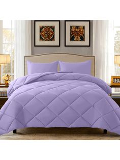 a bed with purple comforter and pillows