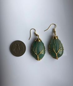 A pair of big charming teardrop-shaped green or pink hanging earrings, with gold wired tree of life wire wrapped artistically on the green or jade stones. They are so unique and eye-catching, hard to not notice when you wear them. Some highlights of these lovely gold family tree jade earrings are: *High-quality materials Quality green or pink jade stones, hand-wired in the tree of life wires. *Eye-catching design Simple and unique. The tree of life symbolizes the previous life, harmony, and fami Bohemian Teardrop Pendant Jewelry With Ear Wire, Handmade Bohemian Green Crystal Earrings, Unique Green Teardrop Earrings For Gift, Nature-inspired Teardrop Wire Wrapped Jewelry, Bohemian Green Handmade Crystal Earrings, Green Teardrop Bohemian Jewelry, Bohemian Green Teardrop Jewelry, Nature-inspired Gold Wire Wrapped Earrings, Green Wire Wrapped Crystal Earrings As Gift