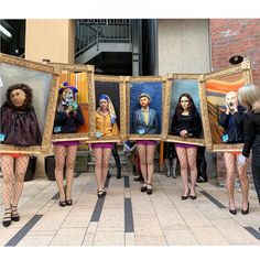 several people are dressed in costumes and holding paintings