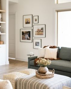 a living room filled with furniture and pictures on the wall above it's coffee table