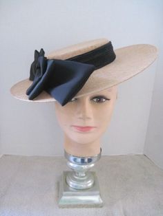 *  This classic design features a tan Sinamay hat form with a jumbo black satin bow.  It is slightly oval and the bow can be worn on either the right side or left side of the head. *  The black elastic band secures the design and it is light weight and comfortable to wear. *  Designed for any Easter Event, Mother's Day Celebration, Derby occasion, Wedding Event, Fashion Show, Birthday Celebration, Garden or Tea Party, Baby or Wedding Shower, Ladies Gathering or just for fun. Formal Hat With Ribbon And Curved Brim, Elegant Adjustable Hat With Bow, Formal Wide Brim Hat With Ribbon, Fitted Evening Hats With Bow, Classic Black Boater Hat For Party, Evening Hats With Bow And Short Brim, Evening Hat With Ribbon And Curved Brim, Adjustable Bow Boater Hat For Kentucky Derby, Chic Boater Hat With Bow And Curved Brim