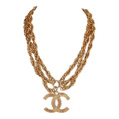 This vintage Chanel necklace is in 24K gold plated metal and has a large etched classic CC pendant with three rope chains and spring ring closure. Origin: FranceCollection: 1980sCondition: Vintage; Excellent. Minor signs of wear, including light brushing and tarnishing. Accompanied by: Chanel boxMeasurements: 16" chain, 1.75" pendant