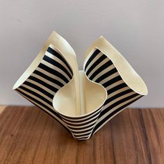 two black and white striped bowls sitting on top of a wooden table