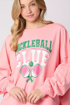 Get ready to rock the court with the Peach Love Cotton Terry "Pickleball Club" Graphic Printed Oversized Sweatshirt. Made from soft and cozy cotton terry, this sweatshirt features a trendy graphic print and an oversized fit for ultimate comfort. Perfect for your next pickleball game or casual hangout, this sweatshirt is a must-have for any pickleball club member. Details:- Oversized- Sleeve Panel- Asymmetric High-low Cut Fabric Content:- 85% Cotton, 15% Polyester Pink Varsity Tops For Game Day, Pink Crew Neck Sweatshirt For Sports Season, Pink Relaxed Fit Varsity Sweatshirt, Pink Letter Print Sweatshirt For Sports Season, Pink Varsity Top With Graphic Print, Sporty Pink Tops For Game Day, Casual Pink Sweatshirt For Game Day, Pink Relaxed Fit Varsity Top, Pink Long Sleeve Sweatshirt For Sports Events