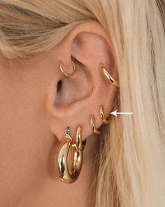 You will never want to take these earrings out! And because of their perfect size, shape and quality, you won't have to! Pair these Luv Aj Sicily Tube Huggie Hoop Earrings in Polished 14k Antique Gold Plated with your favorite large hoop earrings or go-to statement earrings for a layered look. These chunky metal small huggies are perfect for all day wear in the first, second or third hole piercings.Please Note: These are very small, petite huggie hoop earrings. Depending on the wearer's ear size, it may not fit in the traditional lobe piercing. We find these earrings perfect for second or third hole piercings. But again, the fit depends on ear size. Please look at measurements and model pictures to determine if these earrings are a good fit for you!Features:Style: Huggie, HoopMade from pla 3 Earrings One Ear, Earings Impuria Ear Piercing Jewelry, Cute Ear Piercing Jewelry, Ear Piercings Constellation Libra, Multiple Ear Piercing Jewelry, Girly Jewelry Peircinhx, Earrings Impuria Ear Piercing Jewelry, Earrings 4 Piercings, Ear Piercing Huggie