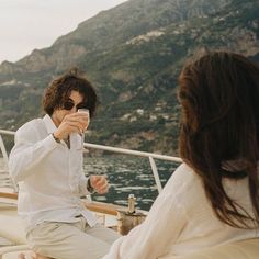 a man sitting on top of a boat holding a cell phone