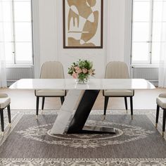 a dining room table with chairs around it and a rug in front of the table