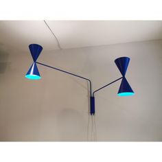 three blue lamps are hanging on the wall