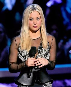 a woman holding a microphone in her hand