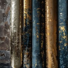 gold and blue paint splattered on an old brick wall