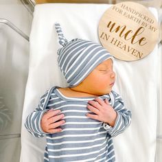 a baby sleeping in a hospital bed with a wooden sign above it that says uncle in heaven