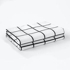 a white and black checkered sheet set on top of each other with two pillows