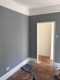 an empty room with hard wood flooring and paint on the walls, in front of a doorway