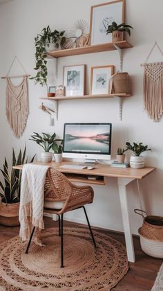 a desk with a laptop on it in front of some potted plants and pictures