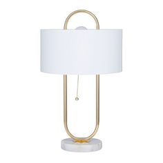 a table lamp with a white shade on the top and a gold metal frame around it