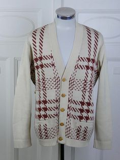 This creamy beige cardigan has a retro geometric pattern in a brick burgundy color, a deep V neckline, and five polished blond wood buttons. Brand label: Adonis Size: Large (42 to 44 US/UK) Material: Cotton, Wool Chest = 46 inches (116.84cm) (this is meant to fit a bit loosely for comfort and ease of movement; it is a best fit for a man with a 42-inch to 44-inch chest) Shoulder Width = 18 inches (45.72cm) Sleeve Length = 25 inches (63.5cm) Cardigan Length = 27 inches (68.58cm) Condition: Excelle Button Down Sweater, Navy Blue Sweater, Wood Buttons, Retro Geometric, Beige Cardigan, Brand Label, Vintage Cardigan, Grey Pullover, Cotton Wool