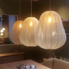 three lamps hanging from the ceiling above a table