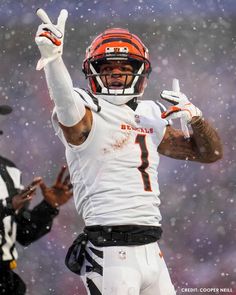 a football player is holding his hand up in the air while wearing an orange and white uniform