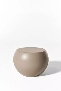 a gray vase sitting on top of a white table