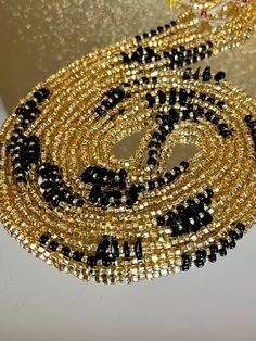 **Please allow up to 5-7 business days for processing time for Waistbeads, Free US Shipping for orders over $75 ** Our stunning Black Love Waistbeads, are perfect for adding a touch of elegance and tradition to your style. These waistbeads feature a beautiful Black and Gold throughout the waistbead. Crafted with high-quality 8/0 and 6/0 glass beads, they offer both durability and beauty. Designed to fit most with a standard length of 60", these traditional tie-on waistbeads allow you to customiz Elegant Waist Beads With Spacer Beads As Gift, Elegant Waist Beads With Spacer Beads For Gift, Elegant Waist Beads As A Gift, Elegant Beaded Waist Beads As Gift, Elegant Beaded Waist Beads For Gift, Elegant Handmade Waist Beads As Gift, Elegant Faceted Waist Beads As Gift, Elegant Gold Beads With Black Details, Party Faceted Round Beads