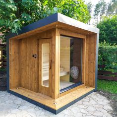 a small wooden sauna in the middle of a garden