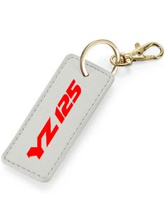 Are you looking for a personalized key ring to treat yourself or to give a gift to a YZ125 enthusiast? This personalized key ring, specially designed for Yamaha YZ 125 enthusiasts, will be perfect! This key ring in synthetic leather-look material is fully customizable and available in 6 colors: blue, white, black, gray, pink or brown. It is particularly intended for owners of YZ 125 from Yamaha. To make it a unique model, you can personalize the color of the text by choosing from 8 colors Key ri White Keychain With Key Clip For Gift, White Keychain With Key Clip Gift, Rectangular White Keychains, Customizable White Keychains For Personalized Gifts, Motorcycle Key, Moto Yamaha, Biker Gifts, Synthetic Leather, Key Ring