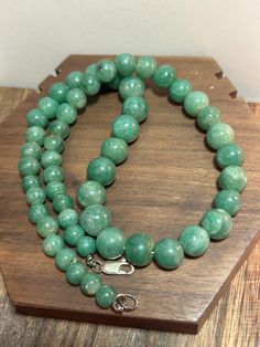 This is a beautiful, vintage, genuine, natural green jade and sterling silver necklace that is 17 1/2 inches. The necklace features natural green jade beads in different sizes that are high-quality and a gorgeous green color. The jade beads range in size from 1/2" in diameter or 17.7mm to 3/8" in diameter or 9.5mm to a little more than 1/4" in diameter or 6.5mm. The necklace weighs an impressive 50.5 grams and is stamped 925. It also has been tested and is genuine jade and sterling silver.  Jade is believed to promote feelings of love, compassion, and self-love, connecting us to our higher selves and fostering a sense of unity with the world around us. Its spiritual properties also include confidence, acceptance, health, and the ability to resolve emotional or spiritual issues. It is also Jade Emerald Necklace With Round Beads For Healing, Emerald Necklace With Round Aventurine Gemstone Beads, Emerald Necklace With Aventurine Gemstone Beads, Green Jade 8mm Beads Jewelry, Hand-strung Round Jade Bead Necklaces, Hand-strung Turquoise Jade Beaded Necklace, Bohemian Style Hand-strung Jade Necklaces, Hand-strung Green Jade Beads, Sterling Necklaces