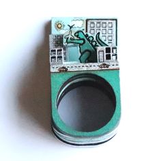 a camera lens holder with an image of a lizard on it's side and a cityscape in the middle