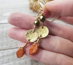 You can almost smell the crisp fall air with these boho autumn earrings. dainty brass disc's are hammered to perfection and adorned with rich green Czech glass and pumpkin orange fall leaves. Finished with 14k gold plated earring hooks. - Gorgeous boho autumn styling - Brass materials - Czech glass beads - 14k gold plated earring hooks with rubber backs included Rustic Brass Earrings For Gift, Earthy Nickel-free Brass Jewelry, Earthy Brass Dangle Earrings, Rustic Brass Dangle Earrings, Rustic Gold Brass Earrings, Rustic Hammered Brass Jewelry, Nickel-free Brass Earthy Earrings, Earthy Nickel-free Brass Earrings, Rustic Gold Drop Earrings