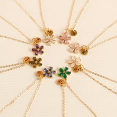 a bunch of necklaces are arranged in a circle on a white surface with gold chains