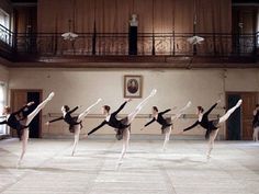 a group of ballet dancers standing in a large room