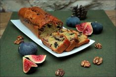 a loaf of fruit bread on a plate with figs and nuts