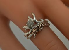 a close up of a person's hand wearing a ring with flowers on it