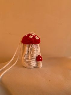 a crocheted bag with a red mushroom on the front and white mushrooms on the back