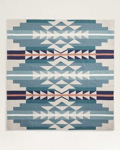 a blue and white rug with an abstract design on the front, in different colors