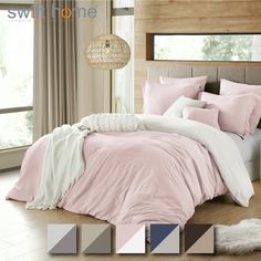 a bed with pink and white comforters in a bedroom