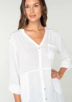 A classic lightweight button-front tunic shirt with side pockets. FINAL SALE Tunic shirt Relaxed, oversize fit Long rolled sleeve with button tab closure Banded collar V-neckline Button front Side pockets Sheer Classic bohemian shirt A must-have addition to any woman's wardrobe, this lightweight shirt adds an effortless laid back feel to any outfit. Featuring long rolled sleeves with a button tab closure, side pockets, and a long tunic length. Throw it on over your swimsuit at the beach, or wear V-neck Tops With Pockets For Vacation, Summer V-neck Tops With Button Cuffs, Oversized Blouse With Roll-up Sleeves And Shirttail Hem, Summer V-neck Blouse With Button Cuffs, Button-up Beach Shirt With Placket Detail, Casual Blouse With Roll-up Sleeves And Shirttail Hem, Casual Split Neck Top With Buttons, Effortless Blouse With Rolled Sleeves And Shirttail Hem, Beach Shirt With Roll-up Long Sleeves