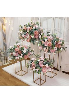 three gold vases with pink and white flowers on them