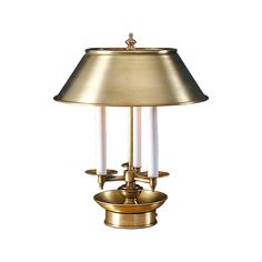 a brass table lamp with two white candles