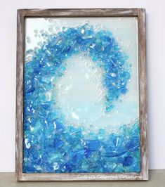 a painting with blue and white paint on the bottom, in an old wooden frame