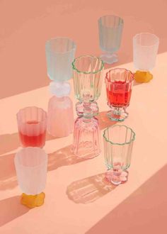 several different colored glass vases sitting on a table