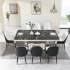 a dining room table with four chairs and a black marble topped table in the middle