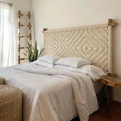 a bed with white sheets and pillows in a room