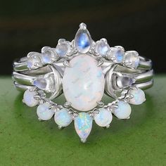 an opalite and diamond ring is shown on a green surface with other opatites